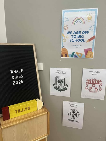 Tillys Greta Poster with colorful drawings reads "We are off to big school." Nearby, a letter board states "Whale Class 2025." School crests from three local primary schools are displayed below.
