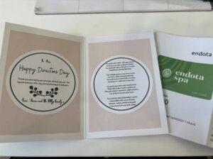 Tillys Gillieston Heights A card with "Happy Director's Day" on the left, a heartfelt message in the center, and an Endota Spa gift card on the right, resting on a table.