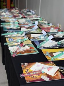 Tillys Rutherford A long black table covered with various children's books, each accompanied by colorful bubble wands and small notes, creating a festive and inviting atmosphere.